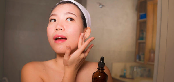 woman doing skincare routine with face serum