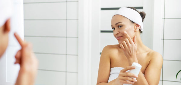 Woman applying a layer of acid serum to her face during her skincare routine