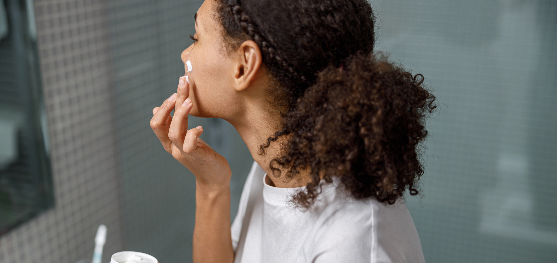 Woman applying multiple face serums in a layered skincare routine