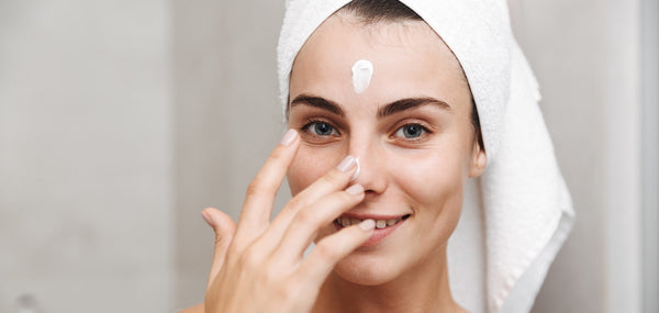 Woman applying CoQ10 serum during her nighttime skincare routine
