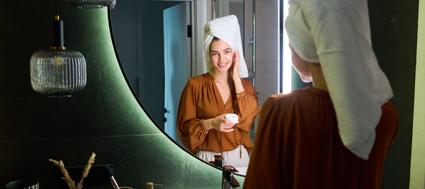 Close-up of a woman applying a spot treatment to acne-prone skin before bed