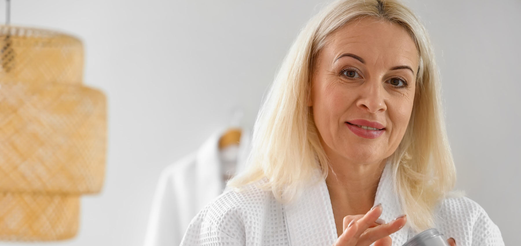 Close-up of a woman smoothing moisturizer onto mature skin before foundation