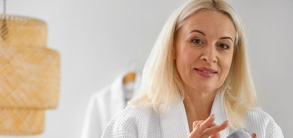 Close-up of a woman smoothing moisturizer onto mature skin before foundation