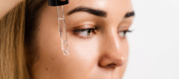 Woman applying a retinol or CoQ10 serum as part of her nighttime routine